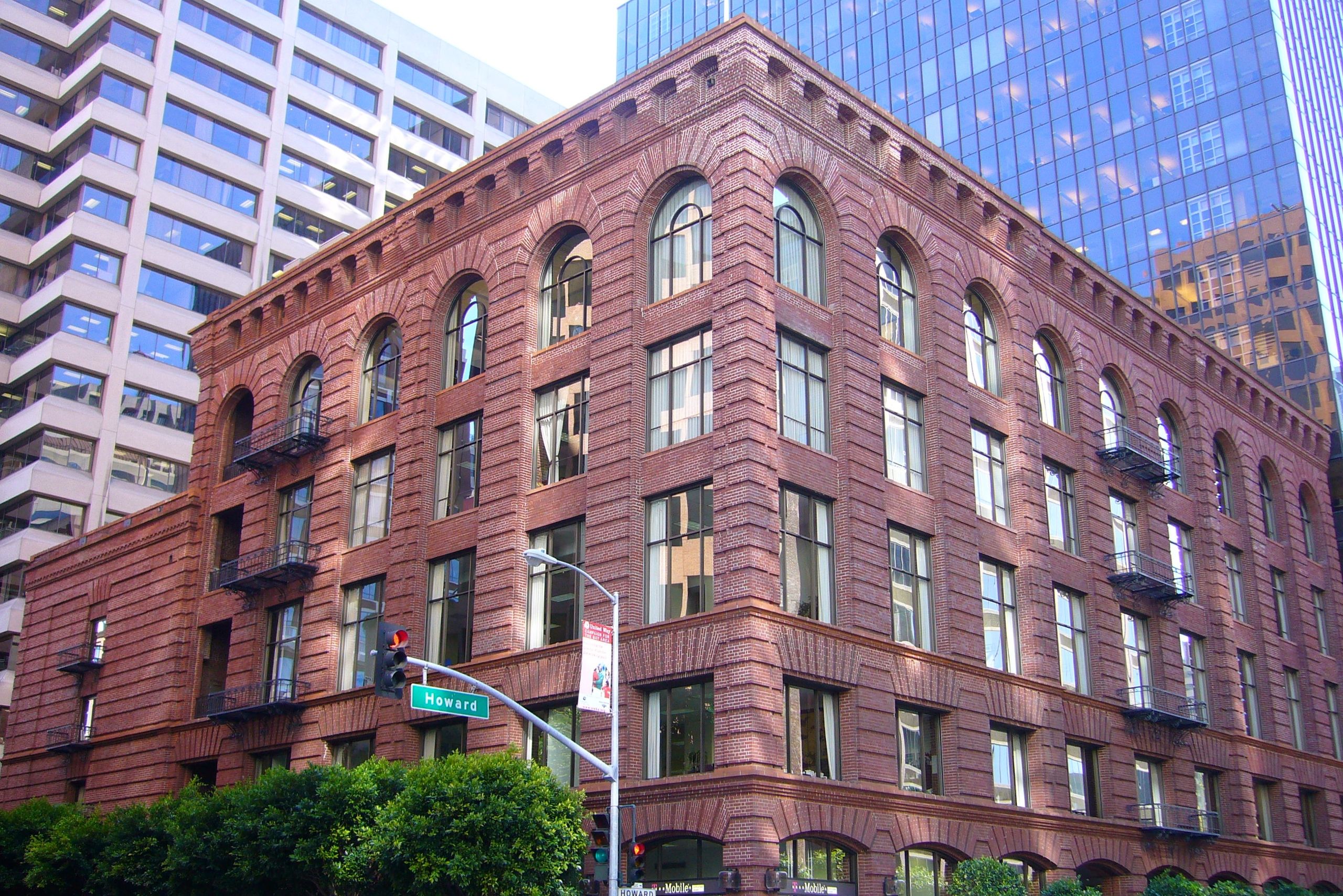 5-story historic brick building in downtown San Francisco, with two taller, modern high rises behind it